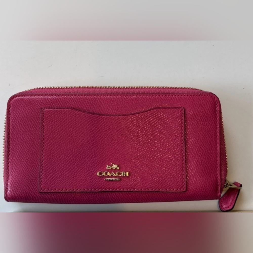 Coach Pink Leather Wallet with Gold Logo and Zip Closure.